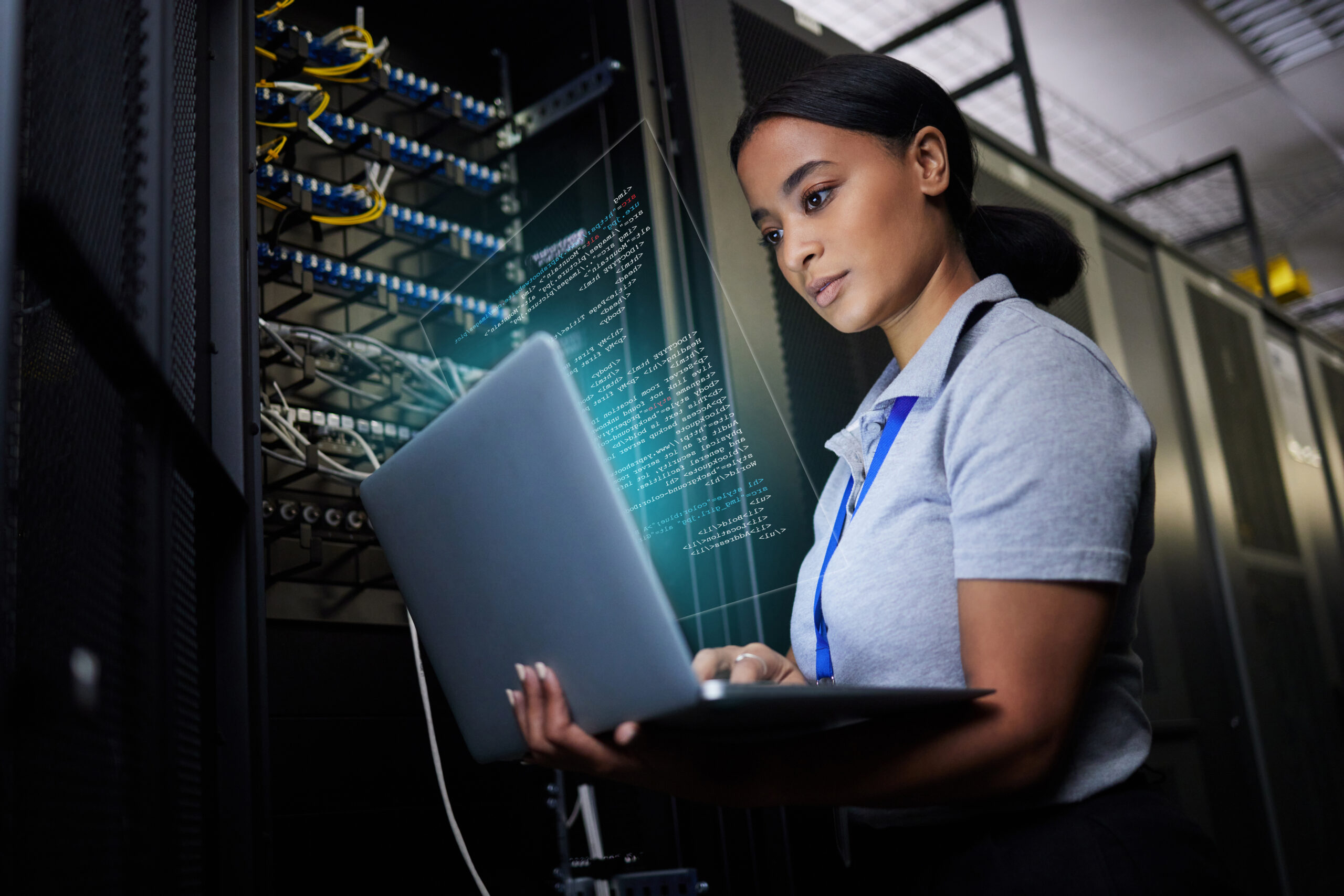 Laptop, network and data center it support engineer working in a dark server room. Computer, cybersecurity and analytics with a female programmer problem solving or troubleshooting.
